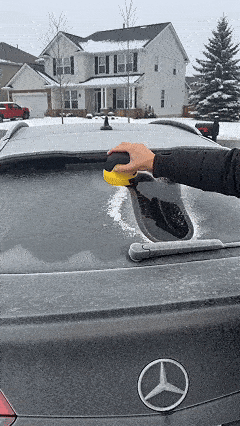 Animated demonstration of a cordless electric ice scraper clearing a frosted vehicle rear window