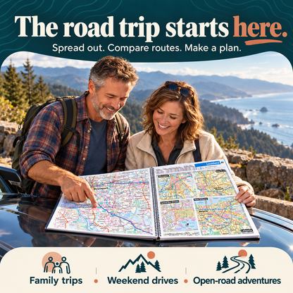 Couple planning a road trip with an open spiral-bound atlas beside a parked car