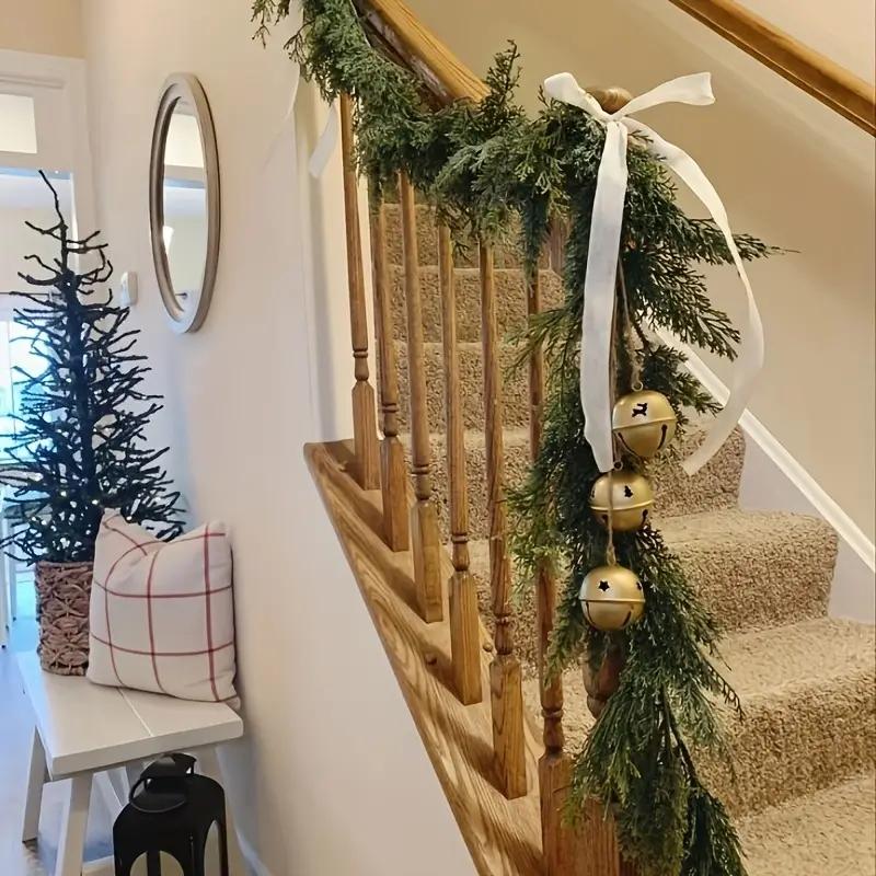 Artificial cedar garland styled on staircase with ribbon and bells