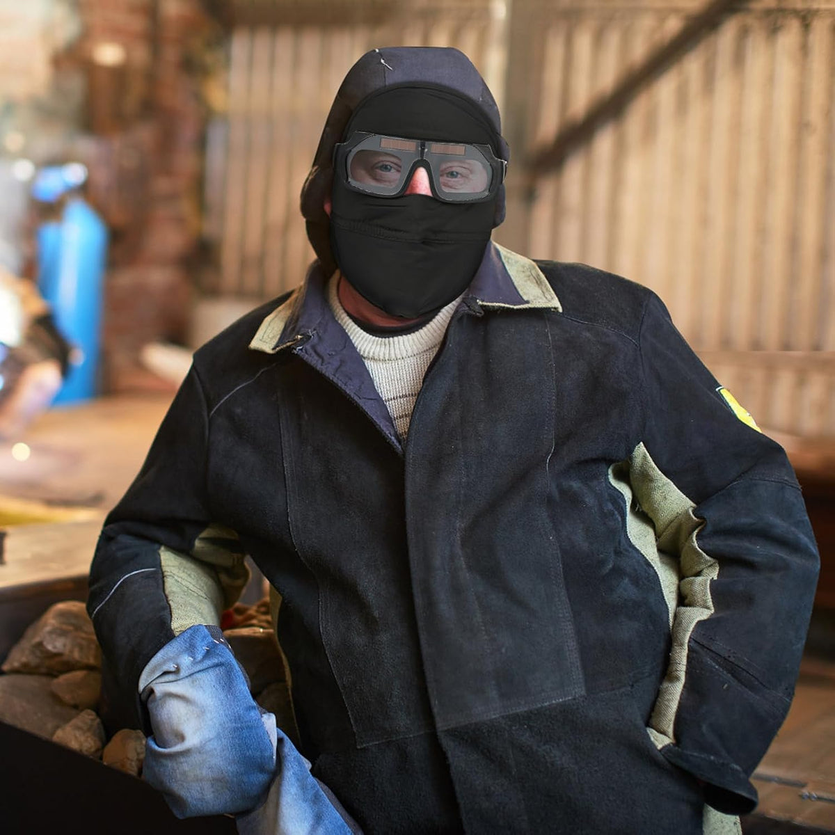 Worker wearing compact welding glasses and face covering