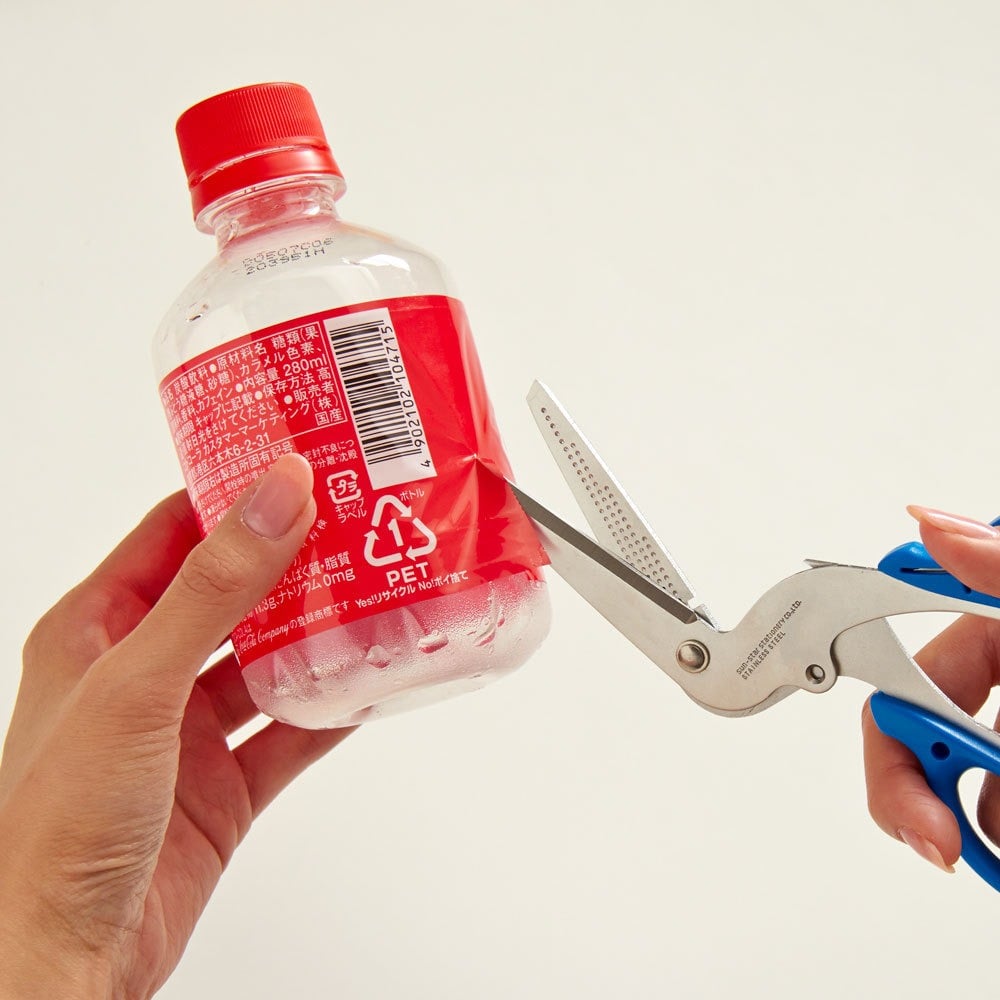 Multi-purpose recycling scissors helping remove plastic bottle label