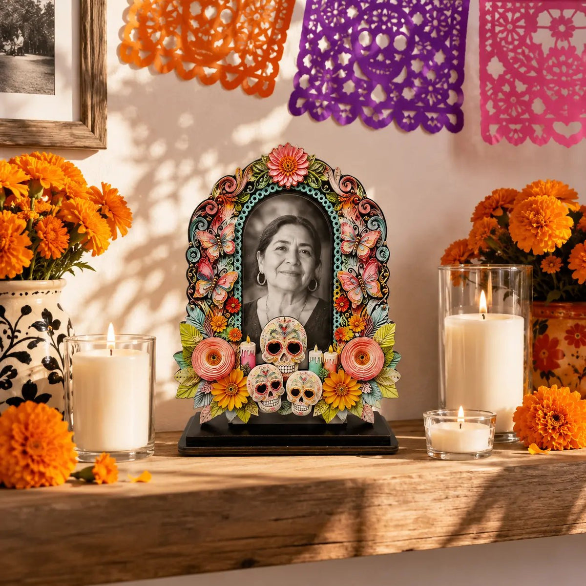 Colorful Día de los Muertos memorial photo frame displayed among marigolds and candles