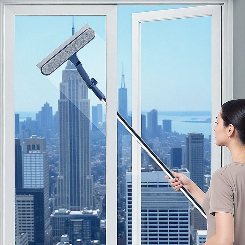 Person using long reach window cleaner on tall exterior-facing glass from indoors