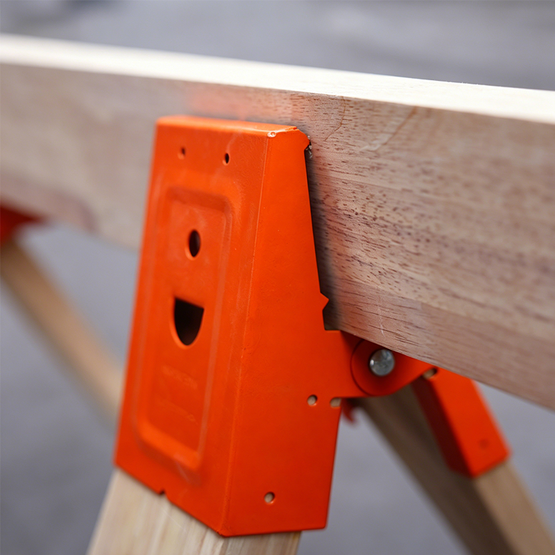 Close detail of reinforced orange folding sawhorse bracket